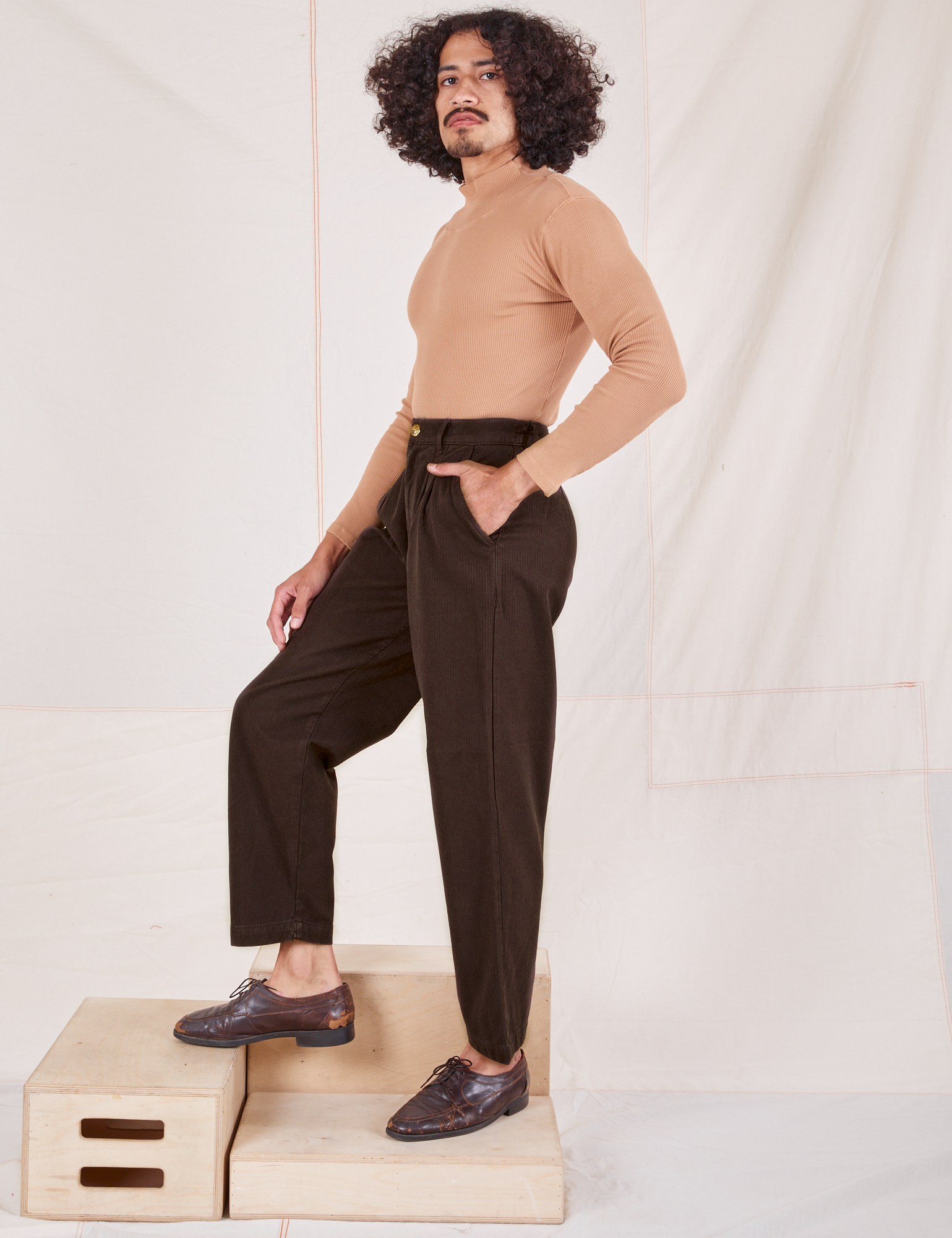 Side view of Heritage Trousers in Espresso Brown and tan Essential Turtleneck worn by Jesse