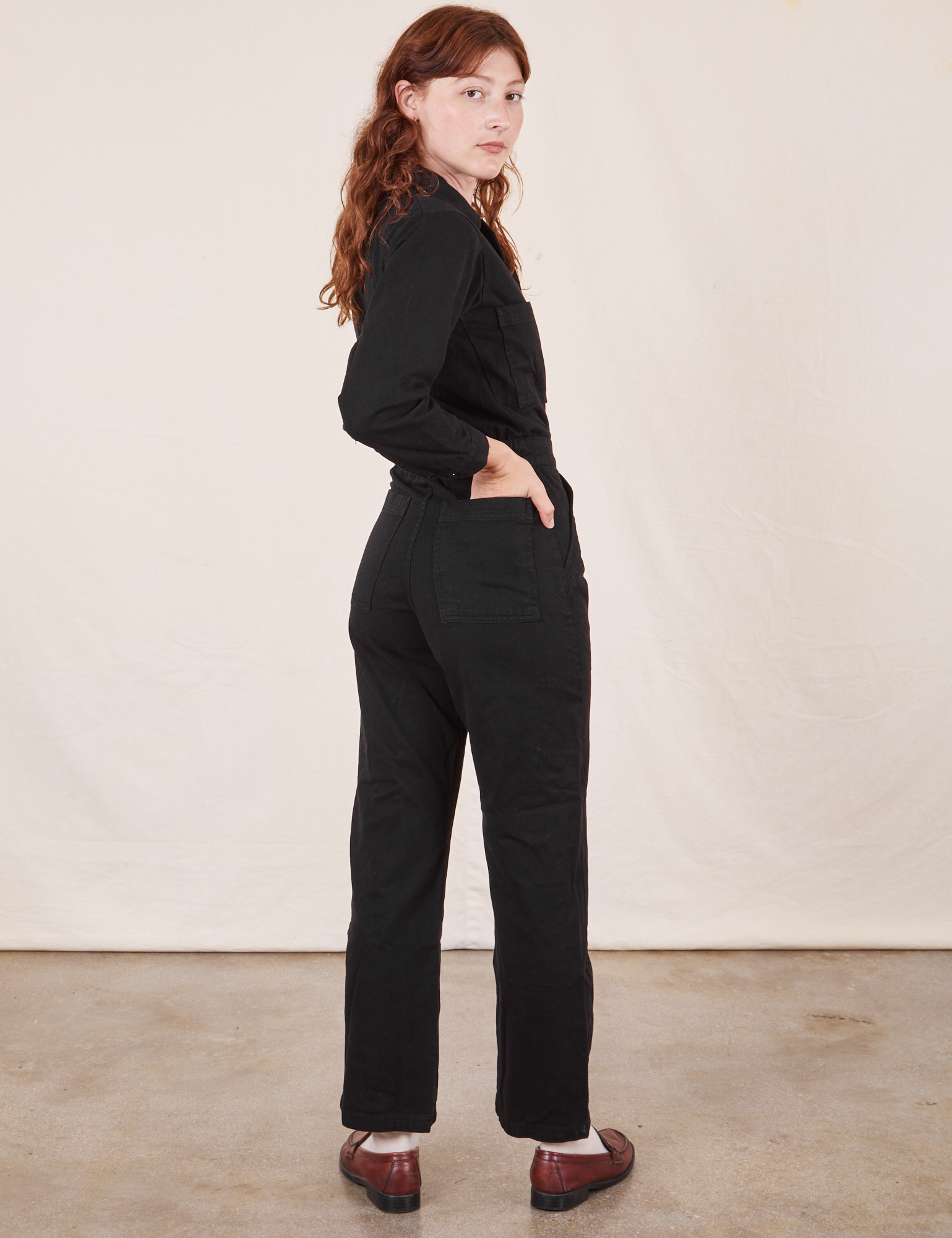 Angled back view of Everyday Jumpsuit in Basic Black worn by Alex