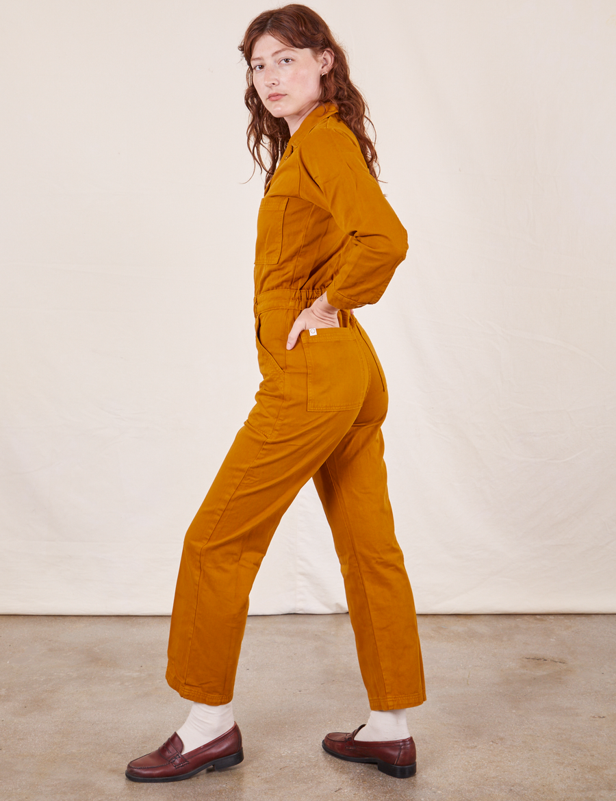 Side view of Everyday Jumpsuit in Spicy Mustard worn by Alex