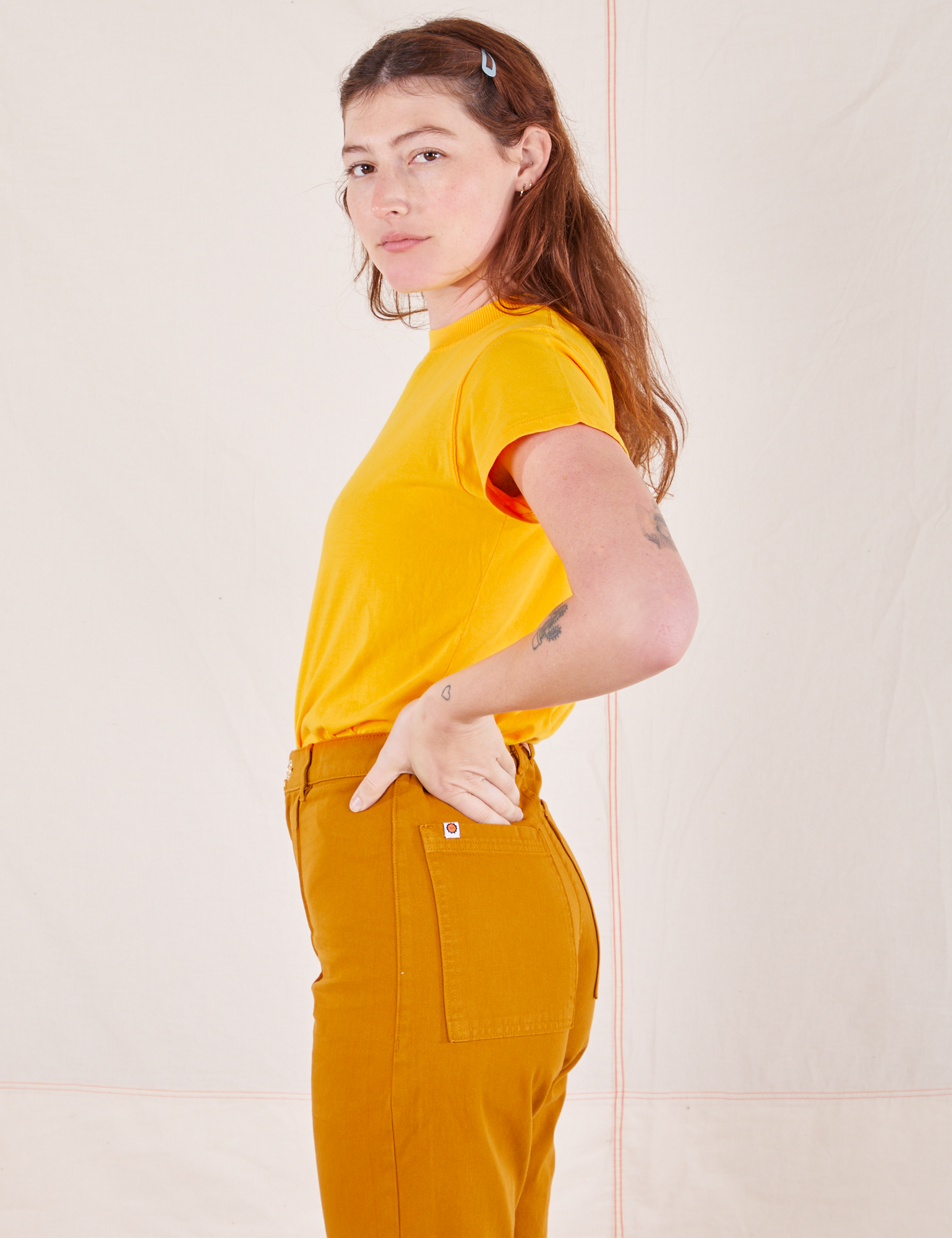 Side view of Organic Vintage Tee in Sunshine Yellow and spicy mustard Western Pants worn by Alex