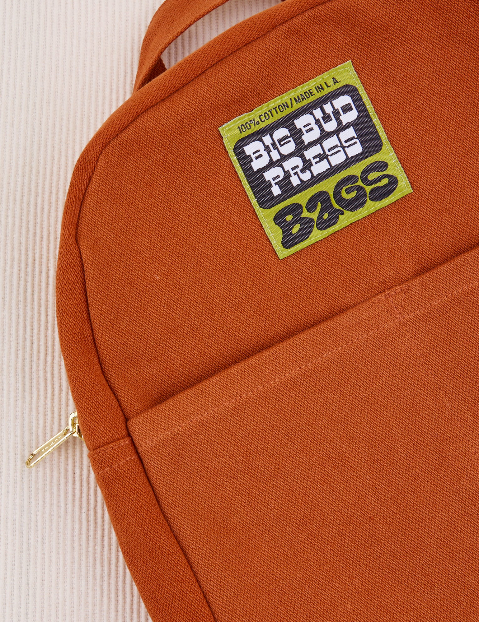 Mini Backpack in Burnt Terracotta close up with green Big Bud Press label