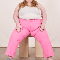 Work Pants in Bubblegum Pink on Catie wearing vintage off-white Tank Top sitting on wooden crate