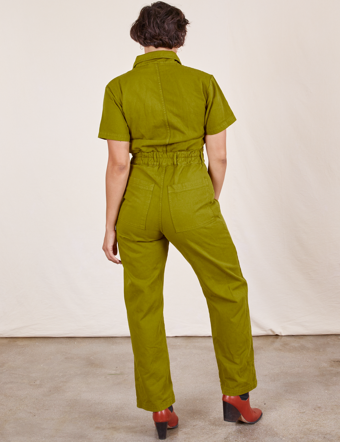 Back view of Short Sleeve Jumpsuit in Olive Green worn by Tiara