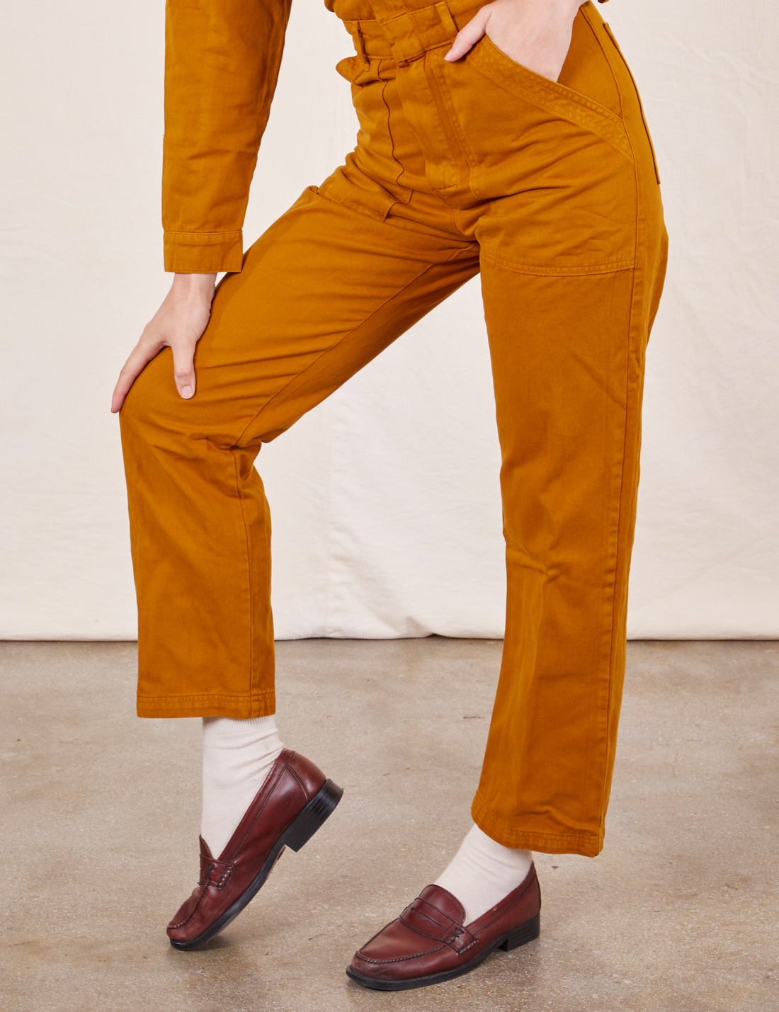Close up of Everyday Jumpsuit in Spicy Mustard pant legs on Alex