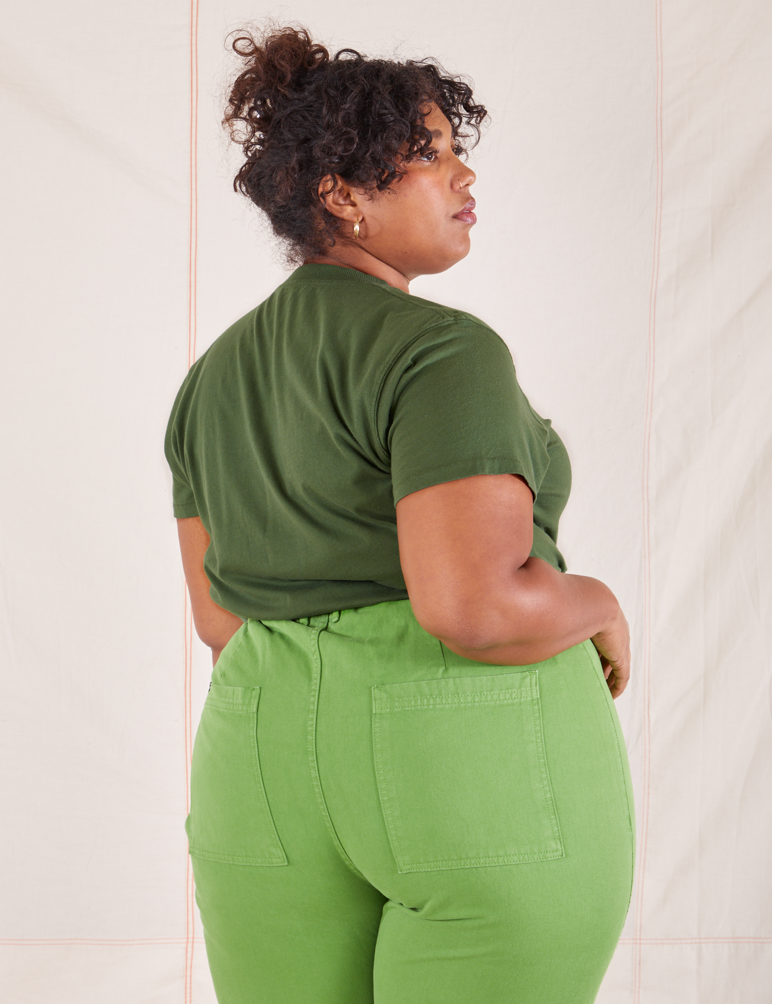 Back view of Organic Vintage Tee in Dark Emerald Green and gross green Western Pants worn by Morgan