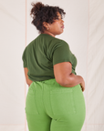 Back view of Organic Vintage Tee in Dark Emerald Green and gross green Western Pants worn by Morgan