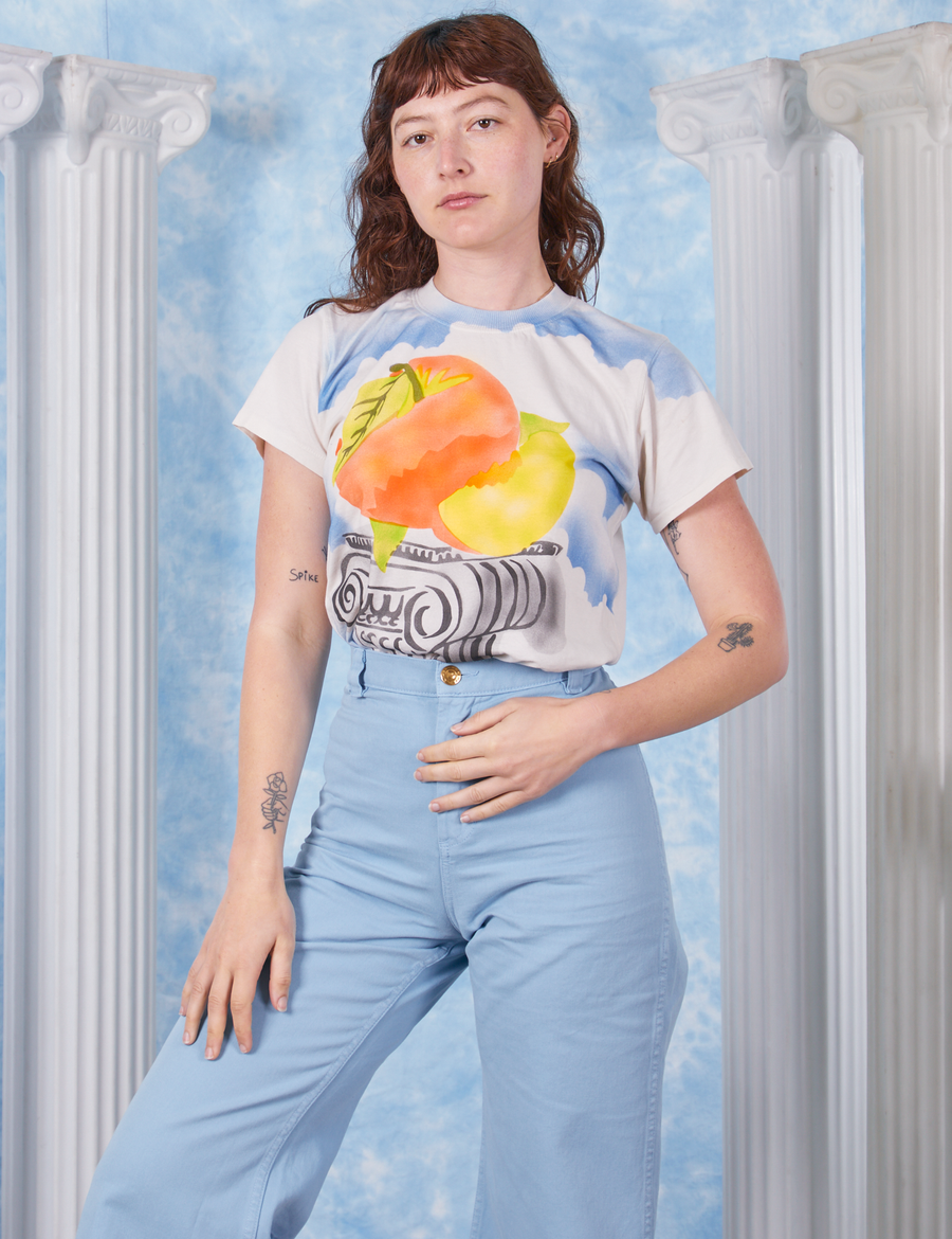 Peach Airbrush Organic Tee on Alex tucked in baby blue Bell Bottoms