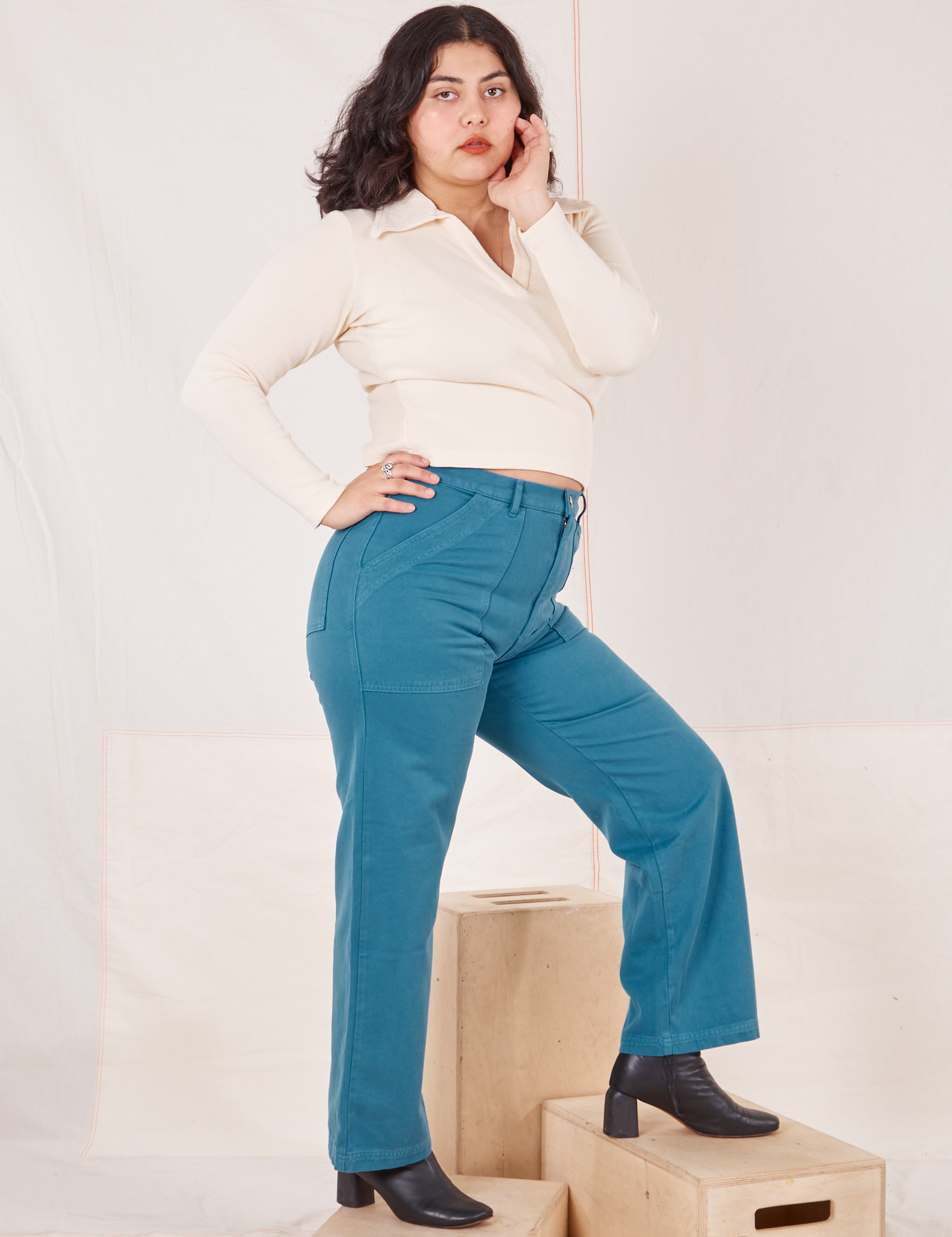 Side view of Organic Work Pants in Marine Blue and vintage off-white Long Sleeve Fisherman Polo worn by Melanie