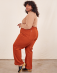 Side view of Western Pants in Burnt Terracotta and tan Essential Turtleneck on Morgan