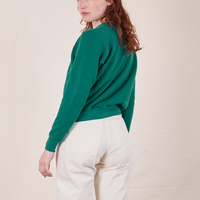 Back view of Heavyweight Crew in Hunter Green and vintage off-white Western Pants worn by Alex