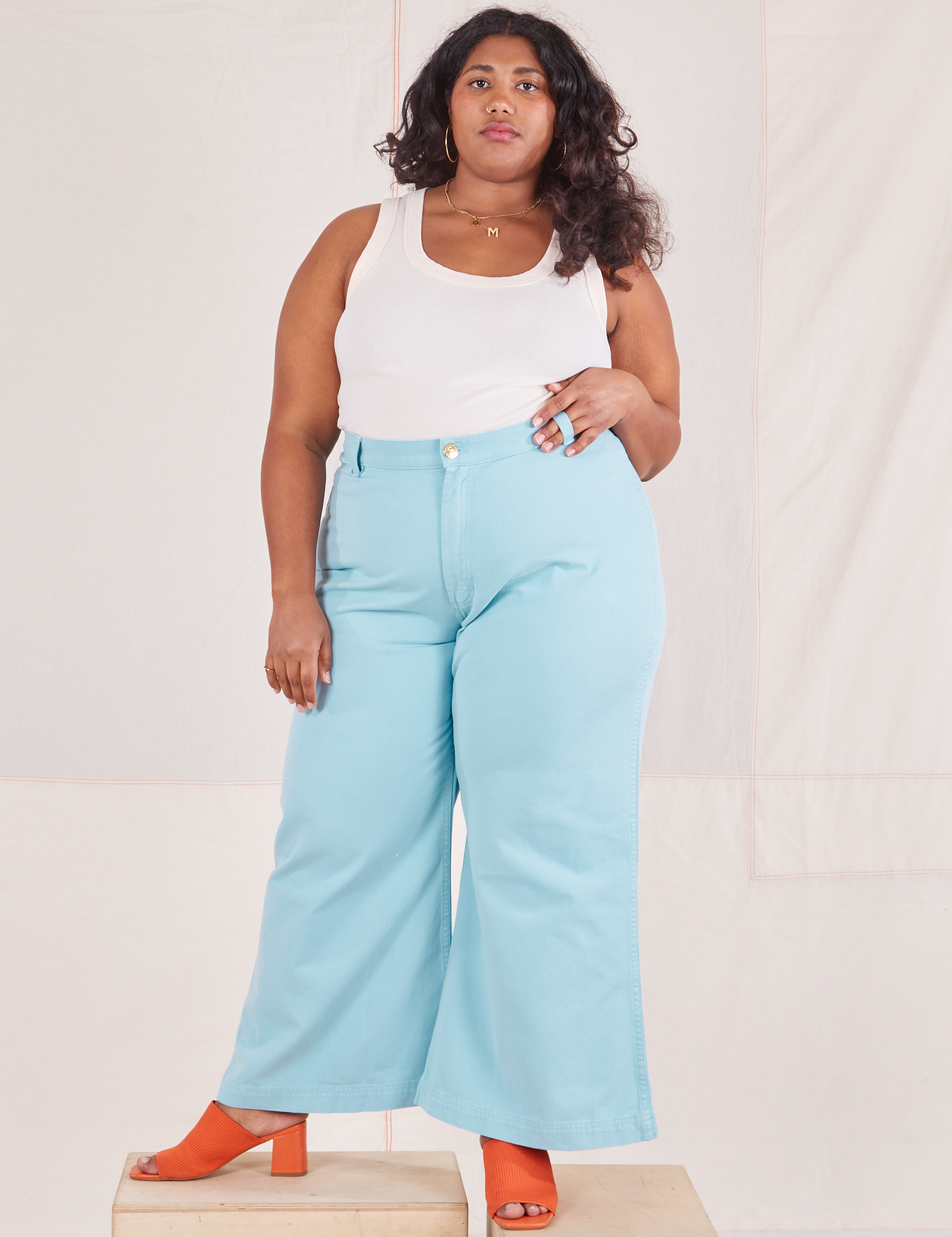 Morgan is 5&#39;5&quot; and wearing 1XL Bell Bottoms in Baby Blue paired with vintage off-white Tank Top