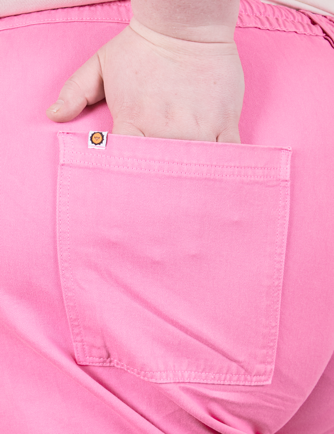 Western Pants in Bubblegum Pink back pocket close up. Worn by Catie with hand in pocket