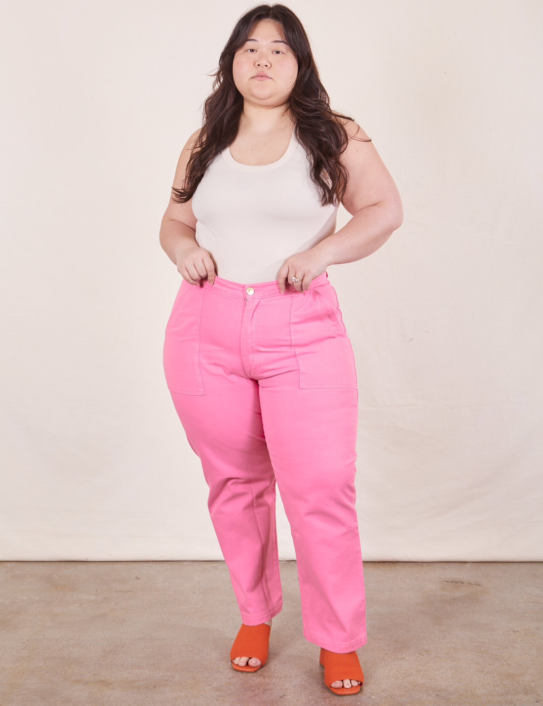 Ashley is 5'7" and wearing 1XL Work Pants in Bubblegum Pink paired with vintage off-white Tank Top