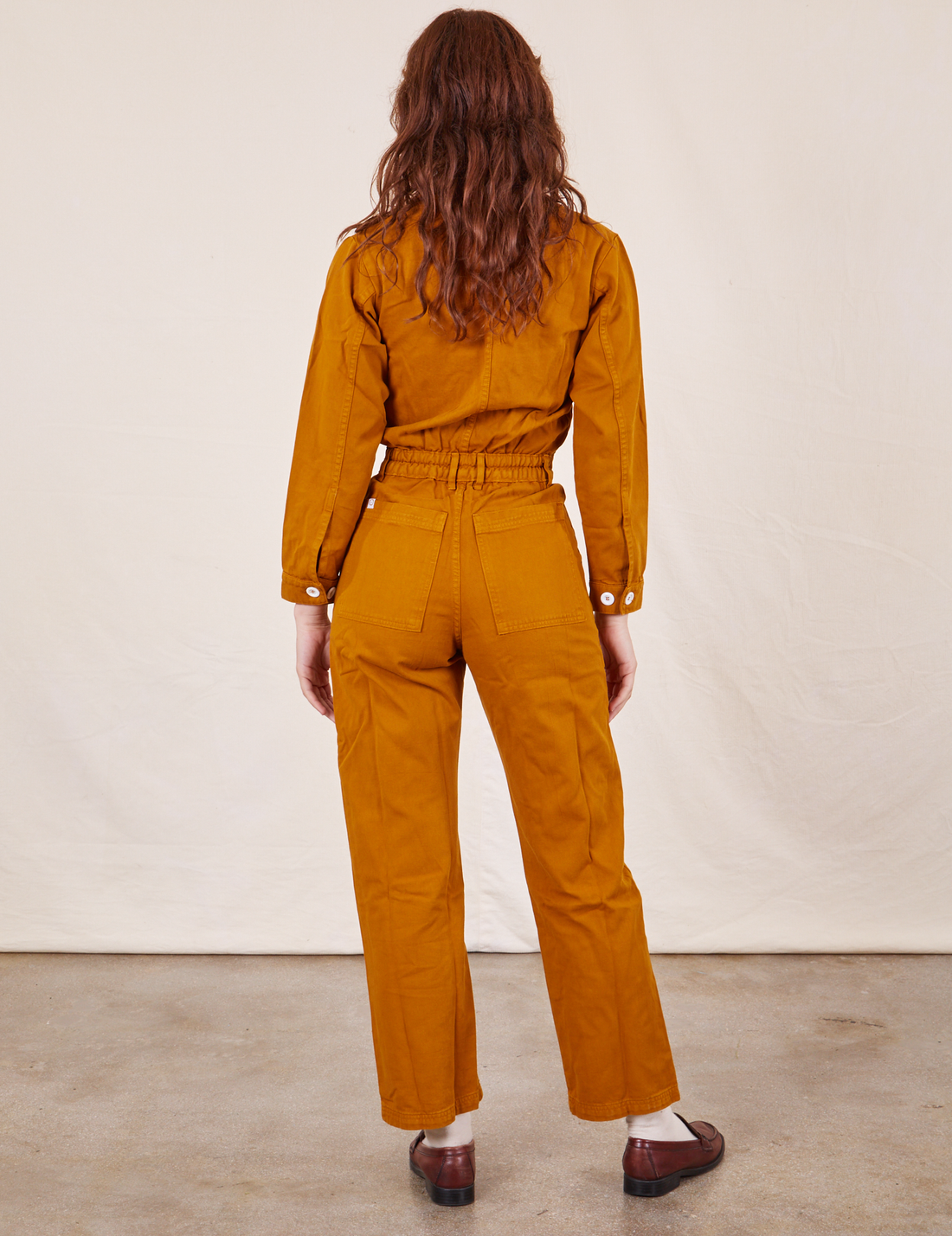 Back view of Everyday Jumpsuit in Spicy Mustard worn by Alex