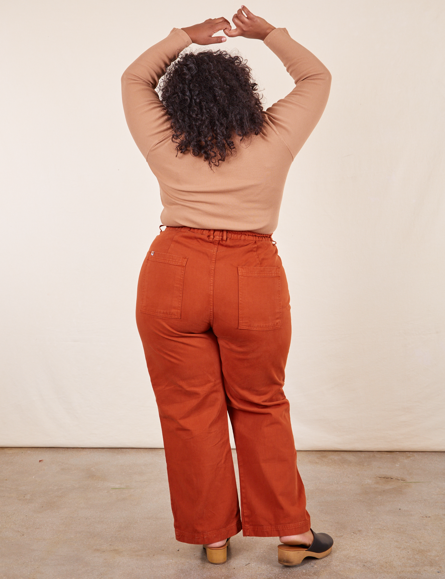 Back view of Western Pants in Burnt Terracotta and tan Essential Turtleneck on Morgan