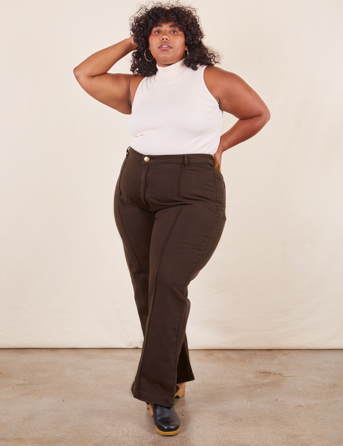 Morgan is 5'5" and wearing 1XL Western Pants in Espresso Brown paired with vintage off-white Sleeveless Turtleneck