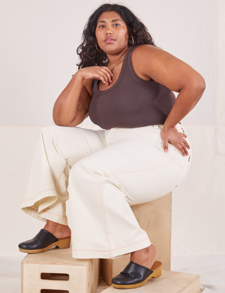 Morgan is sitting on a wooden crate. She is wearing Bell Bottoms in Vintage Off-White and espresso brown Tank Top.
