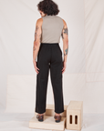 Back view of Heritage Trousers in Basic Black and khaki grey Sleeveless Turtleneck worn by Jesse
