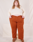 Catie is 5'11" and wearing 5XL Organic Work Pants in Burnt Terracotta paired with vintage off-white Long Sleeve Fisherman Polo