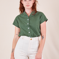 Alex is wearing P Pantry Button-Up in Dark Emerald Green tucked into vintage off-white Western Pants