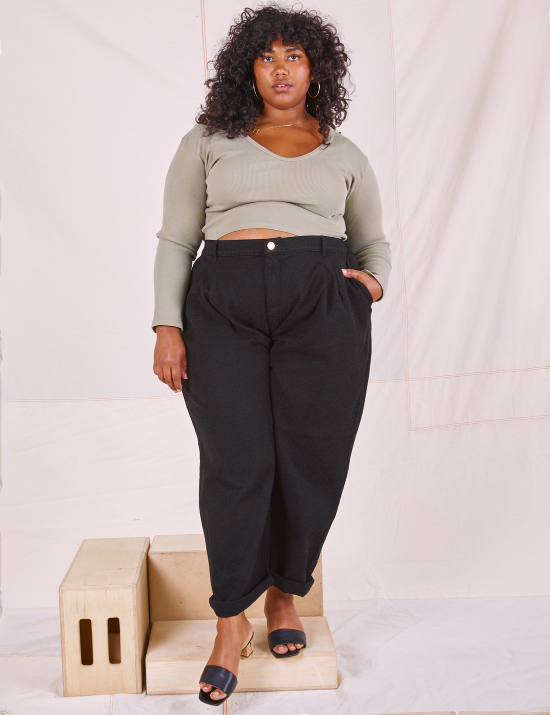 Morgan is 5'5" and wearing 1XL Heritage Trousers in Basic Black paired with khaki grey Long Sleeve V-Neck Tee