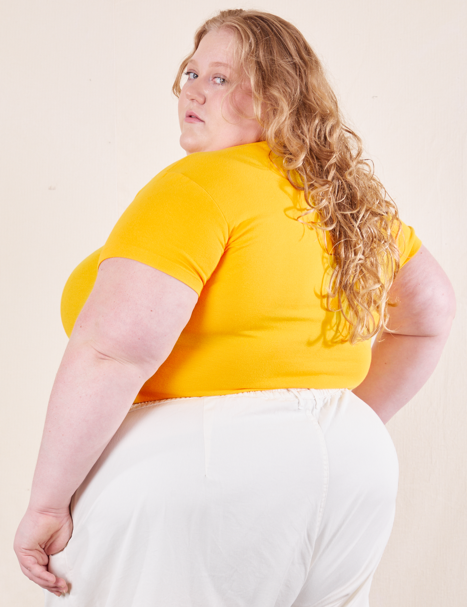 Angled back view of Baby Tee in Sunshine Yellow on Catie