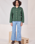 Jesse is wearing Denim Work Jacket in Dark Green Emerald and light wash Sailor jeans