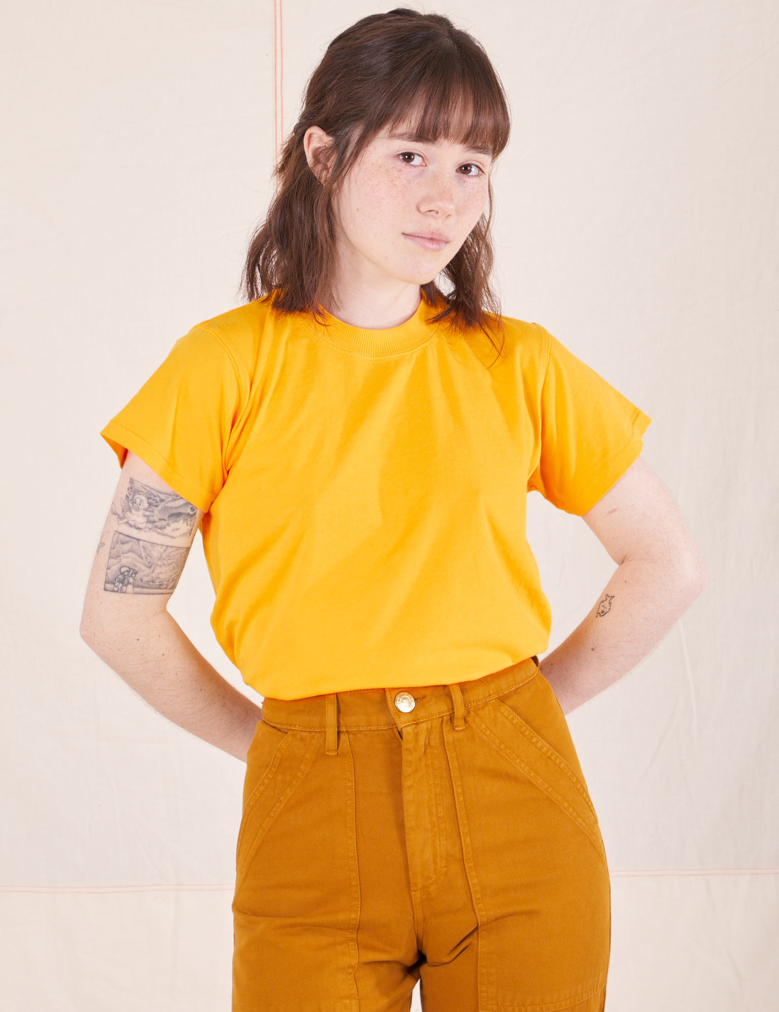 Hana is wearing P Organic Vintage Tee in Sunshine Yellow paired with spicy mustard Western Pants