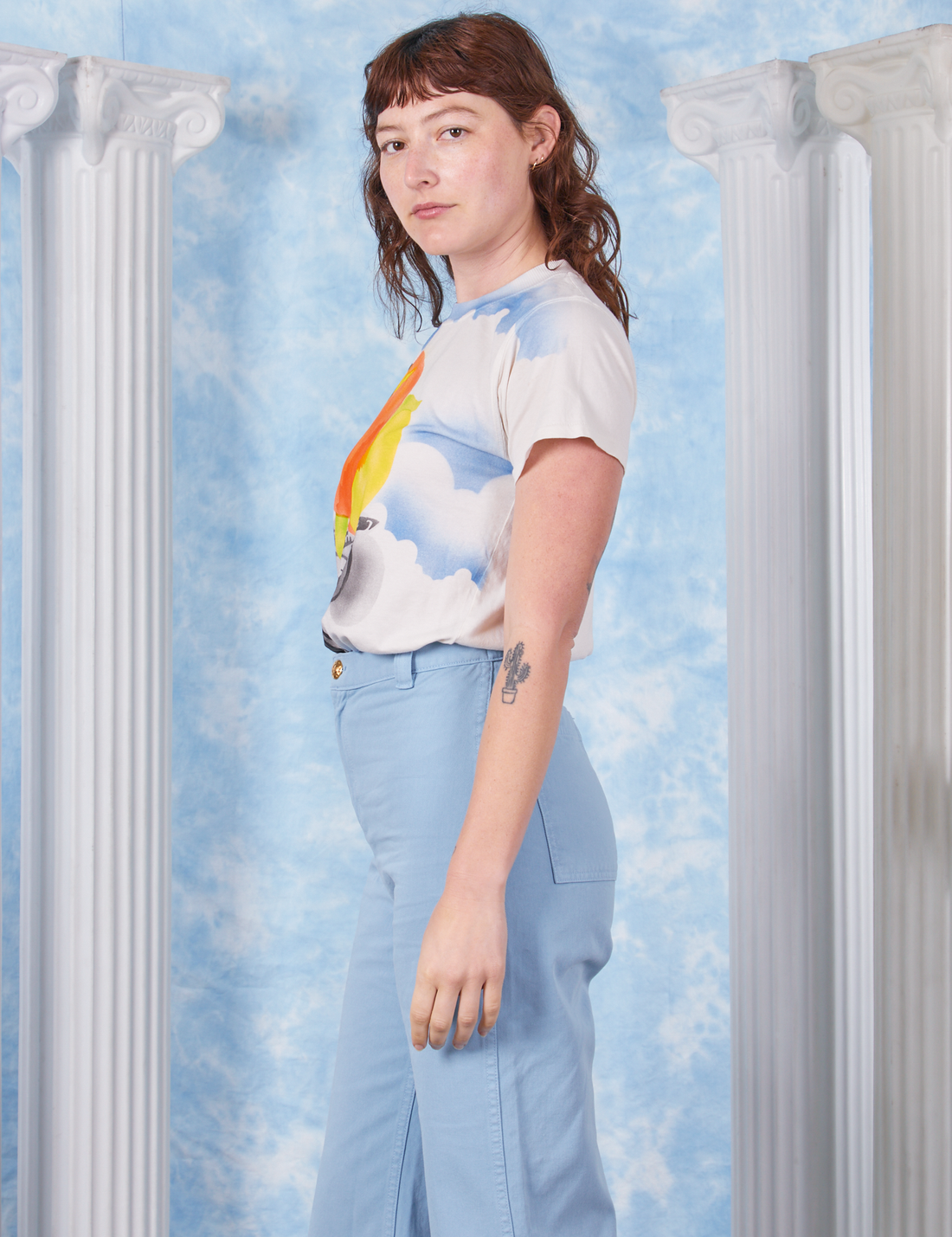 Peach Airbrush Organic Tee side view on Alex wearing baby blue Bell Bottoms
