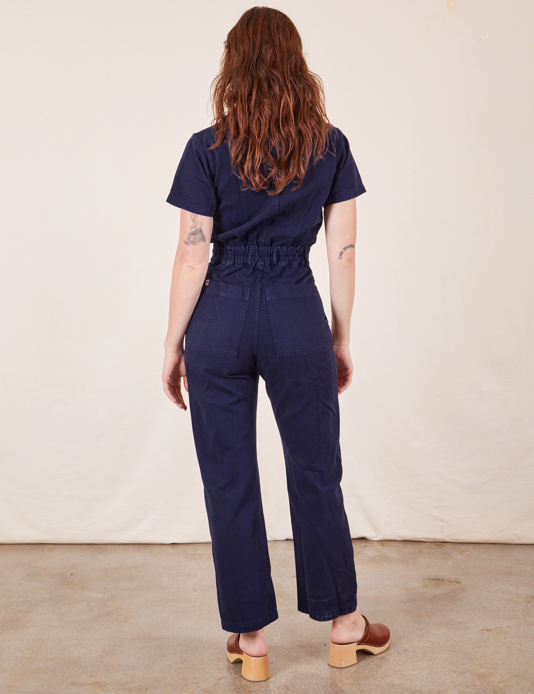 Back view of Short Sleeve Jumpsuit in Navy Blue worn by Alex
