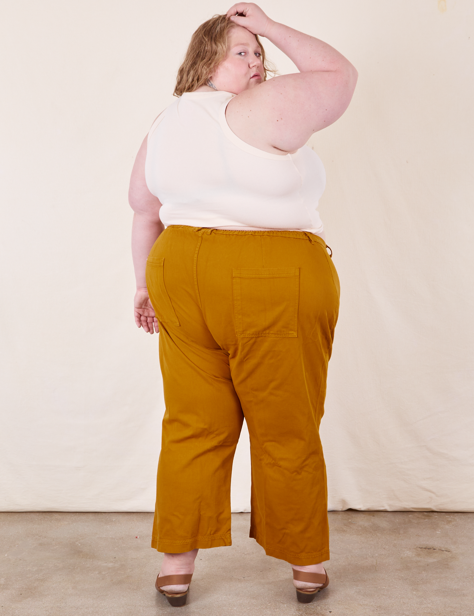 Back view of Western Pants in Spicy Mustard and vintage off-white Tank Top on Catie