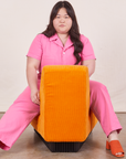 Short Sleeve Jumpsuit in Bubblegum Pink on Ashley sitting in orange upholstered chair