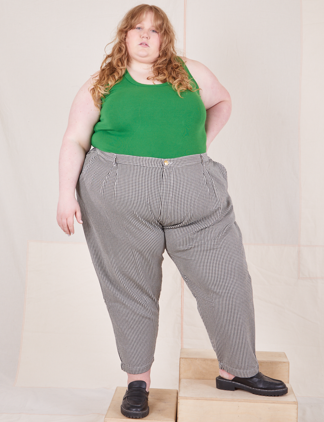 Catie is 5'11 and wearing 4XL Checker Trousers in Black & White paired with forest green Tank Top