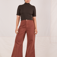 Mika is wearing a size P 1/2 Sleeve Essential Turtleneck in Espresso Brown paired with fudgesicle brown Bell Bottoms
