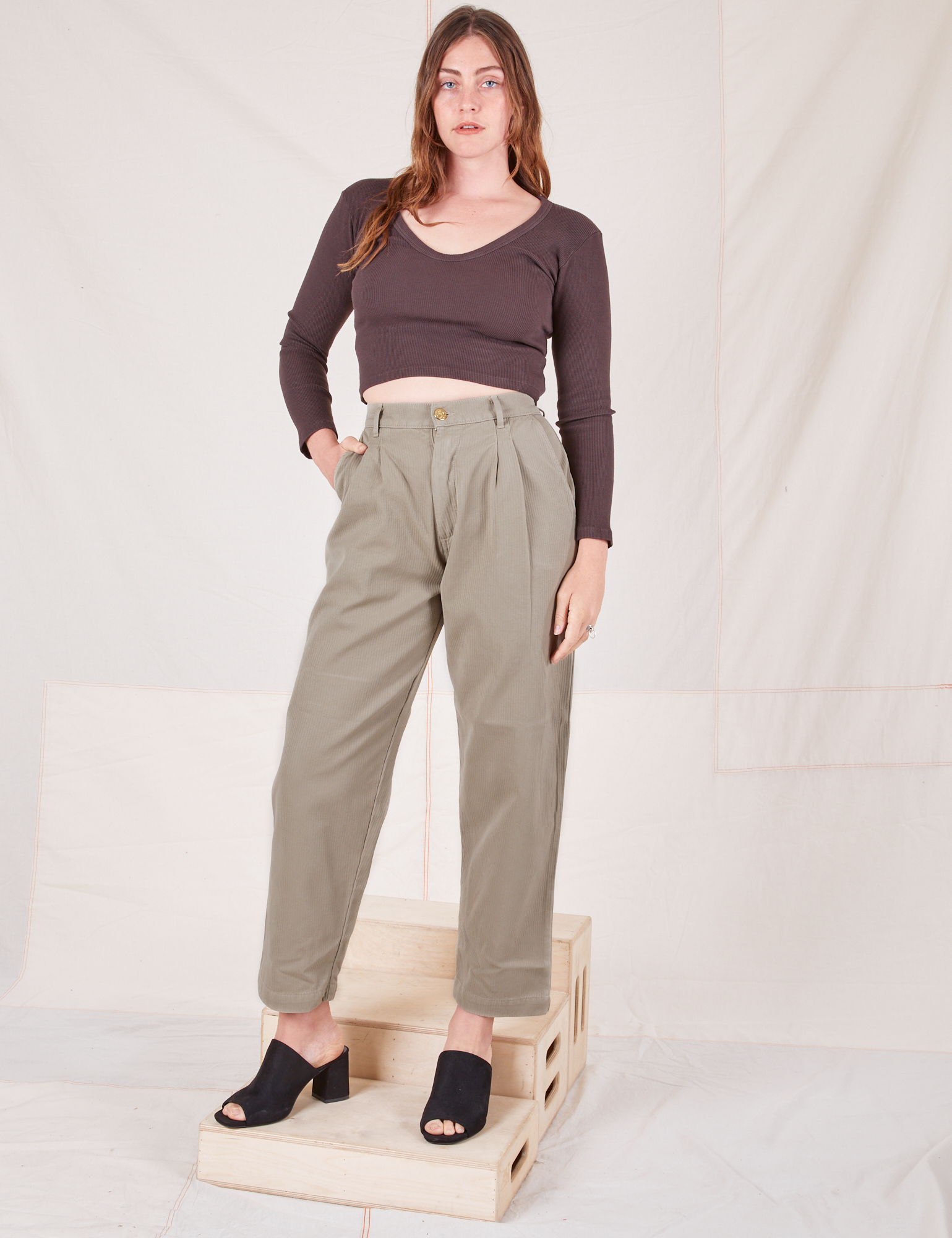 Allison is 5&#39;10&quot; and wearing S Heritage Trousers in Khaki Grey paired with espresso brown Long Sleeve V-Neck Tee