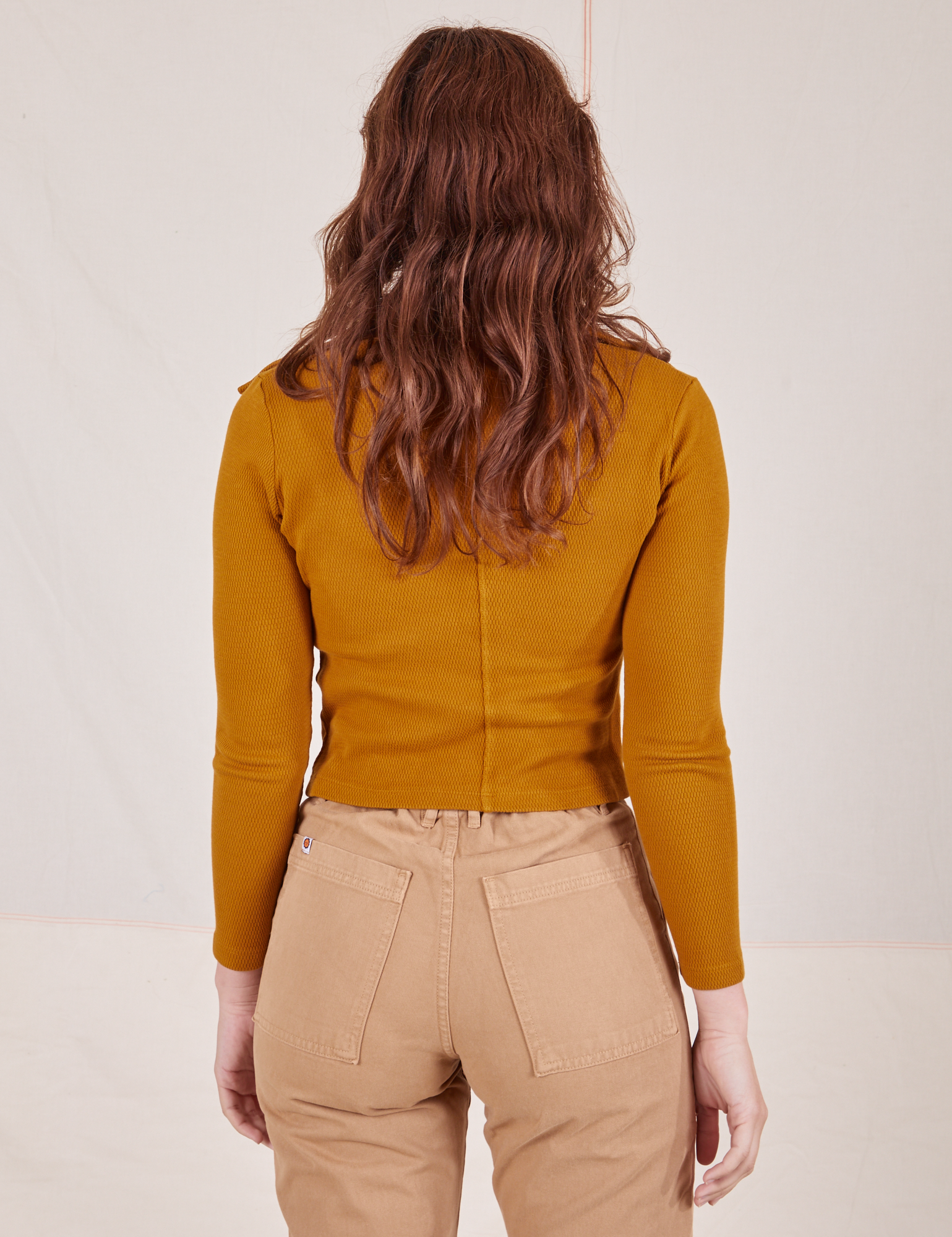 Back view of Long Sleeve Fisherman Polo in Spicy Mustard worn by Alex