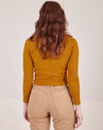 Back view of Long Sleeve Fisherman Polo in Spicy Mustard worn by Alex