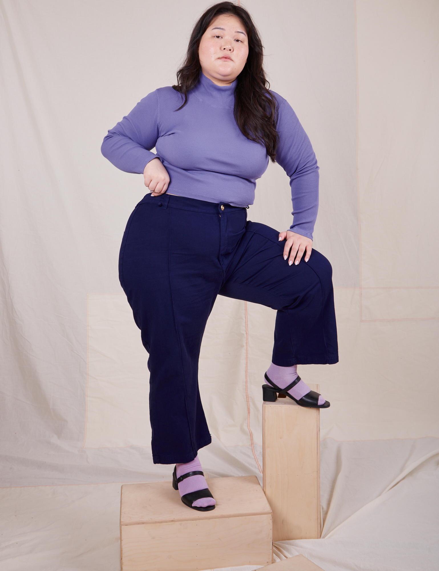 Ashley is wearing Essential Turtleneck in Faded Grape and navy Western Pants