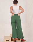 Back view of Bell Bottoms in Dark Emerald Green and vintage off-white Tank Top. Tiara has both her hands in the back pockets.