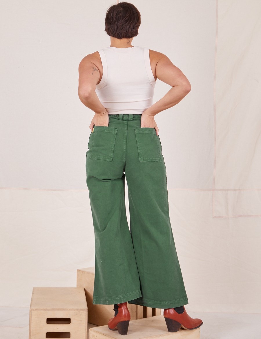 Back view of Bell Bottoms in Dark Emerald Green and vintage off-white Tank Top. Tiara has both her hands in the back pockets.