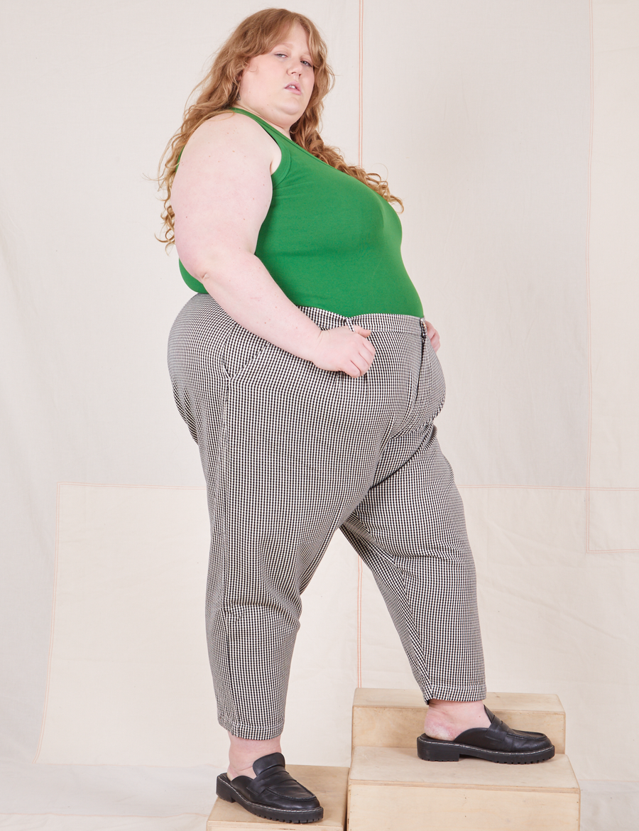 Side view of Checker Trousers in Black & White and forest green Tank Top worn by Catie