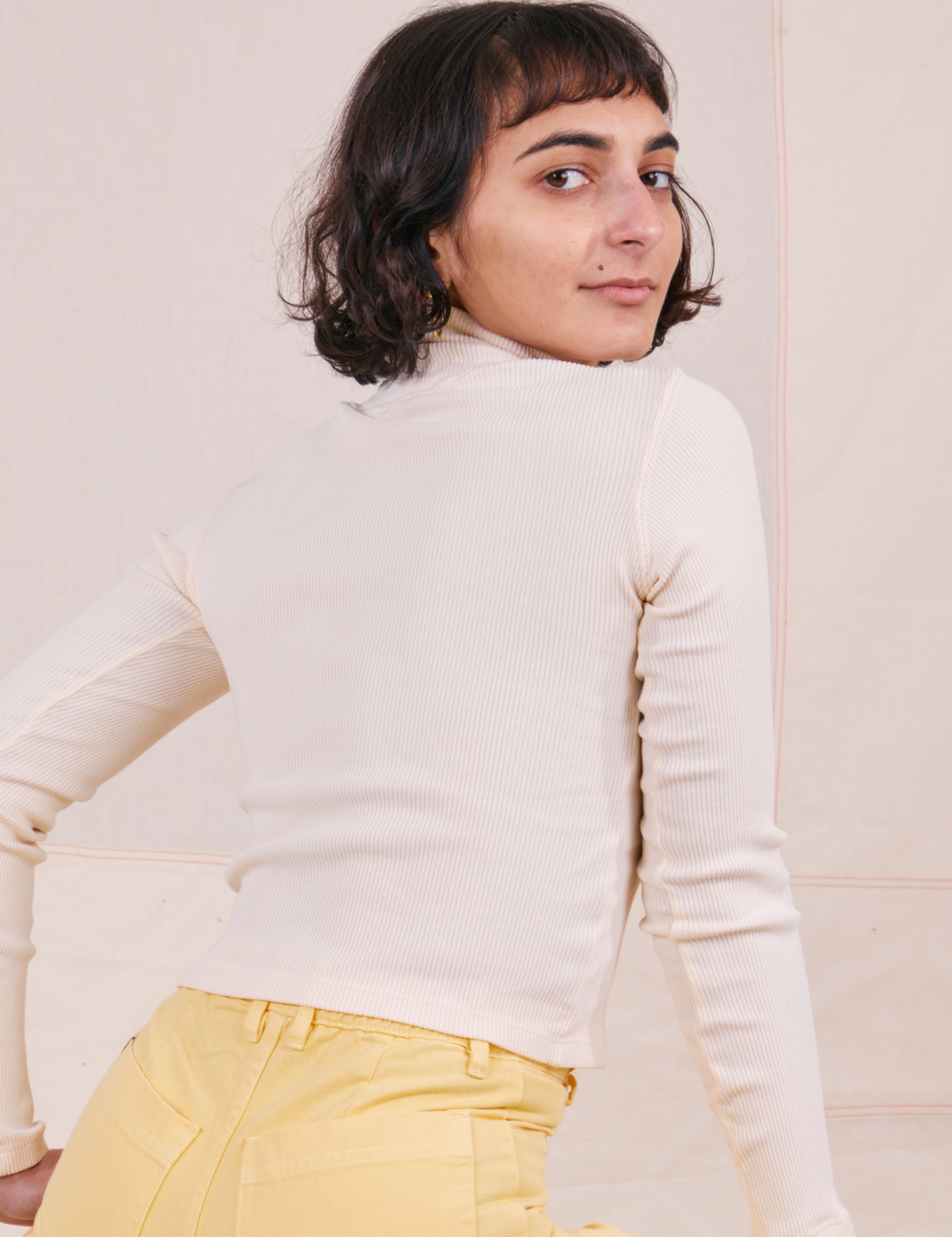 Back view of Essential Turtleneck in Vintage Off-White worn by Soraya