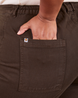 Back pocket close up of Western Pants in Espresso Brown. Worn by Morgan with her hand in the pocket.