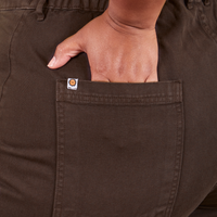 Back pocket close up of Western Pants in Espresso Brown. Worn by Morgan with her hand in the pocket.
