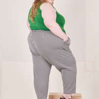 Angled back view of Checker Trousers in Black & White and forest green Tank Top worn by Catie