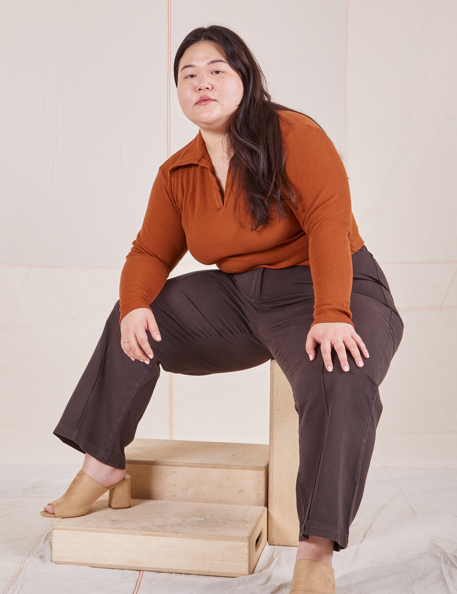 Long Sleeve Fisherman Polo in Burnt Terracotta on Ashley wearing espresso brown Western Pants sitting on wooden crate