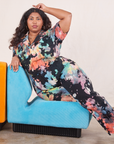 Short Sleeve Jumpsuit in Rainbow Magic Waters on Morgan leaning on turquoise upholstered chair