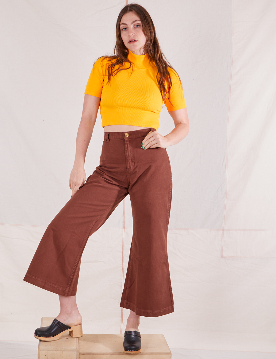 Allison is wearing size XXS 1/2 Sleeve Essential Turtleneck in Sunshine Yellow paired with fudgesicle brown Bell Bottoms
