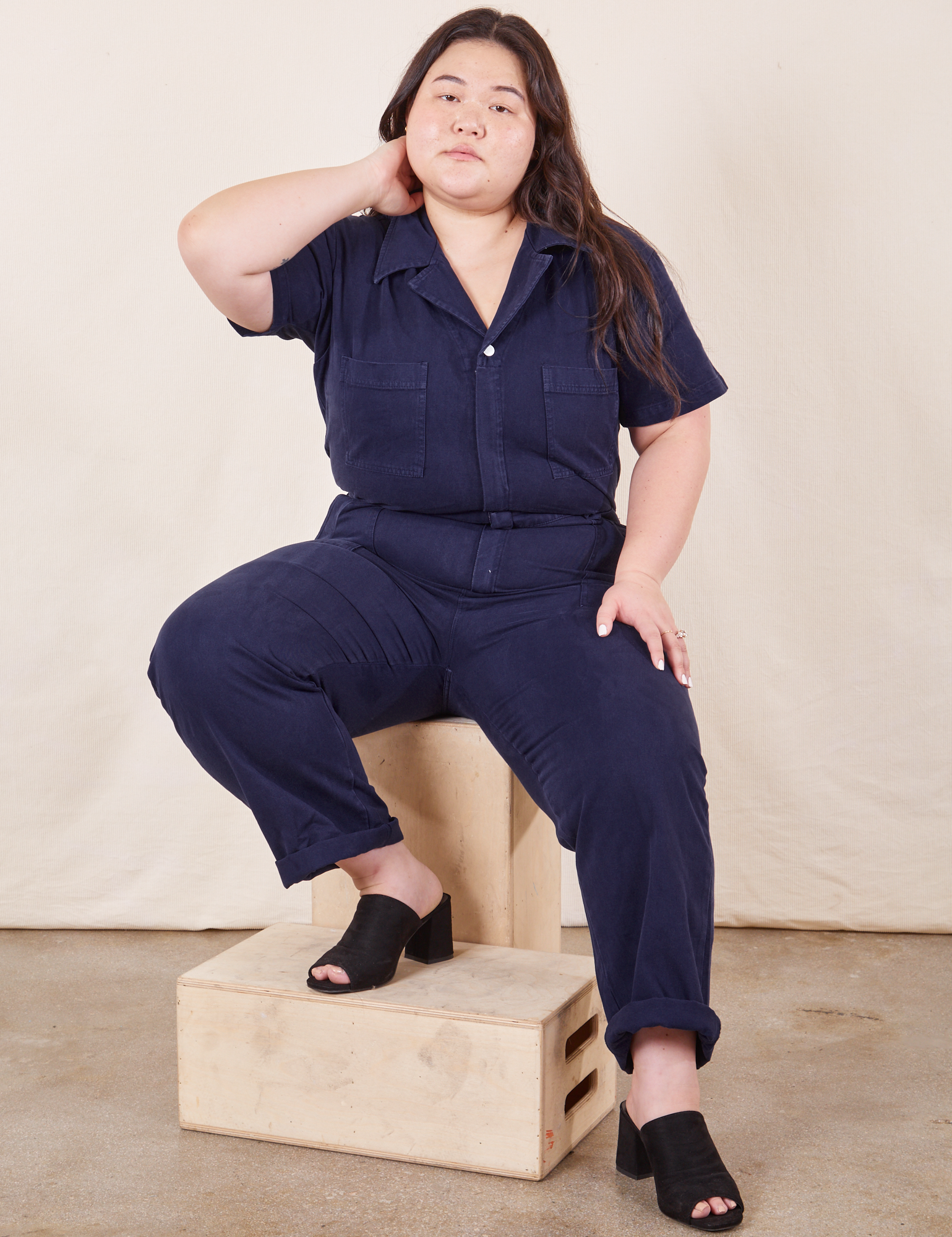 Short Sleeve Jumpsuit in Navy Blue on Ashley sitting on wooden crates