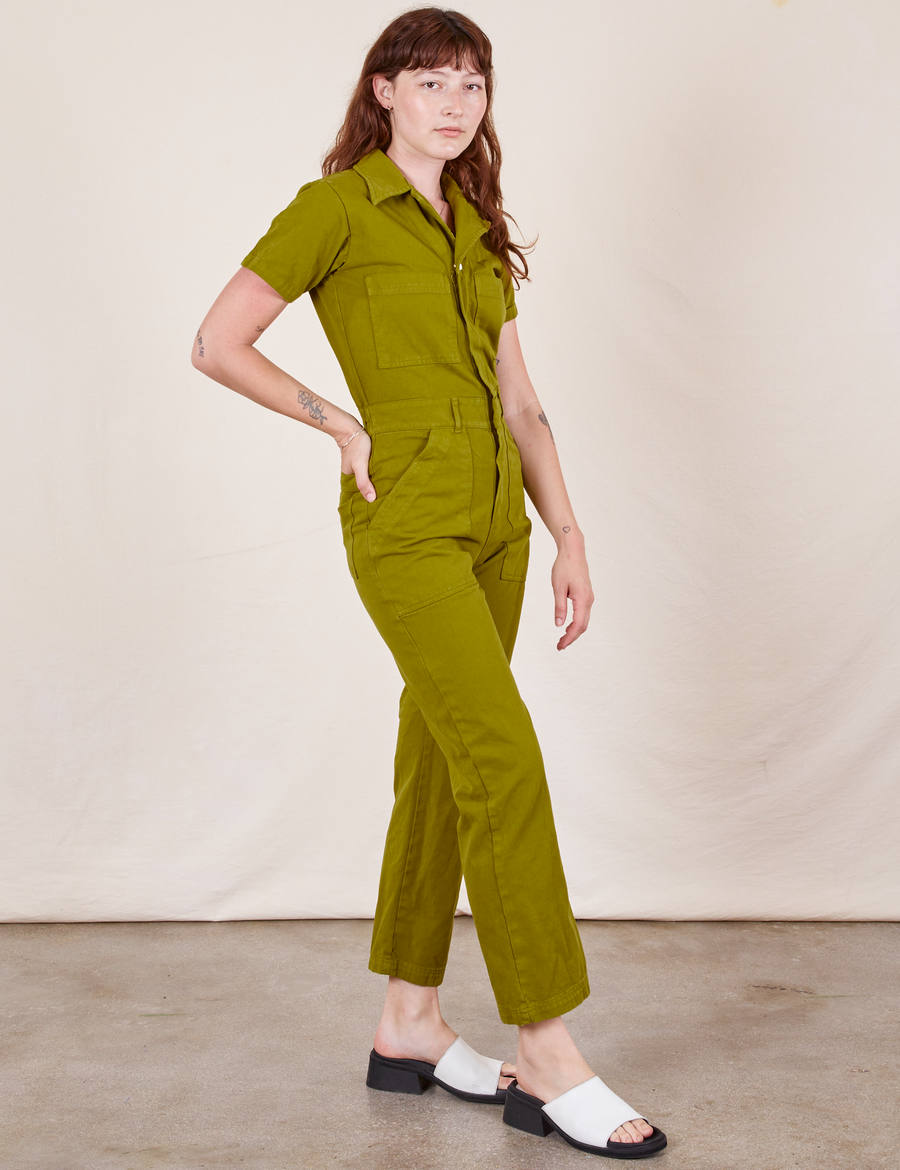 Side view of Short Sleeve Jumpsuit in Olive Green worn by Alex